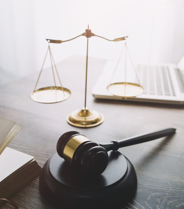 Business and lawyers discussing contract papers with brass scale on desk in office. Law, legal services, advice, justice and law concept picture with film grain effect